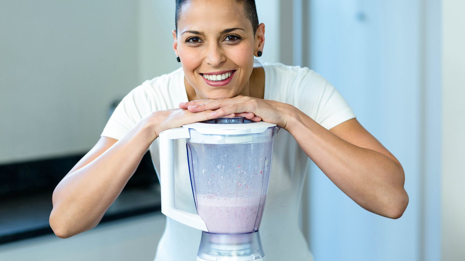 Pregnant woman leaning on blender
